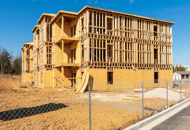 a temporary chain link fence winding around a construction site, outlining the project's progress in Liberty Hill TX